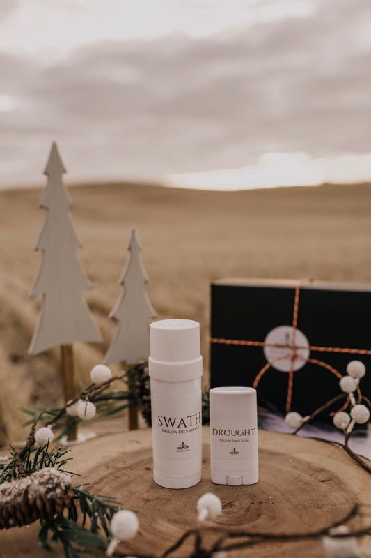 Till & Tallow Swath deodorant and Drought heel balm on a rustic wooden display with winter accents.