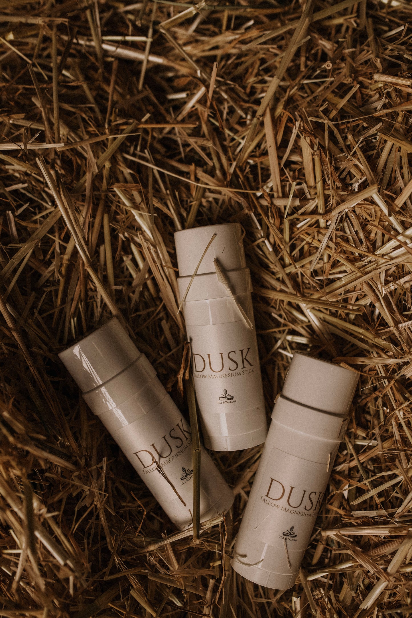 Dusk magnesium tallow sticks laid on straw-natural sleep and muscle recovery product by Till & Tallow, Alberta
