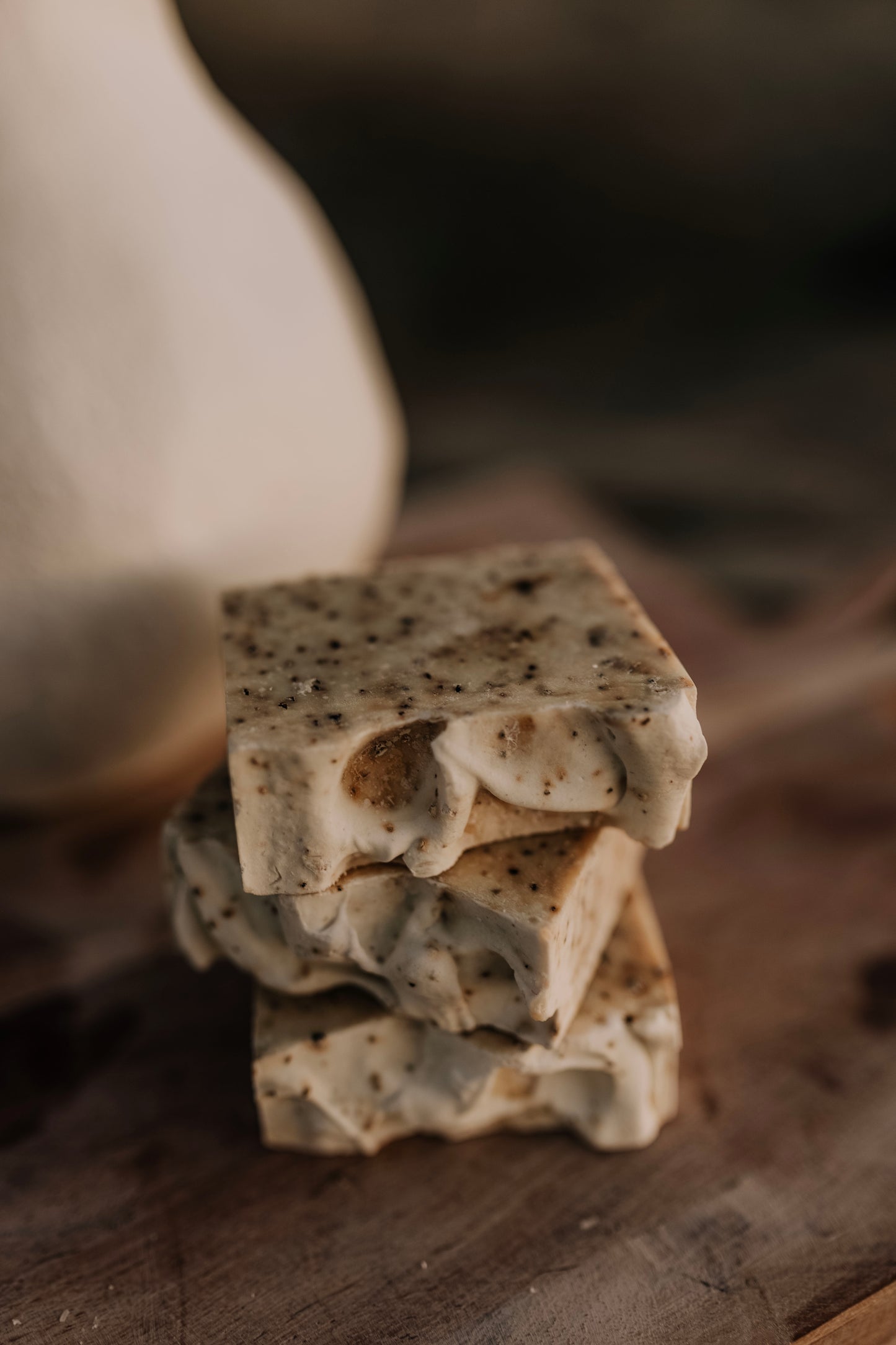 Till & Tallow Bin Bust Soap Degreaser Bars with specked texture stacked on rustic wooden surface, handcrafted in Alberta.