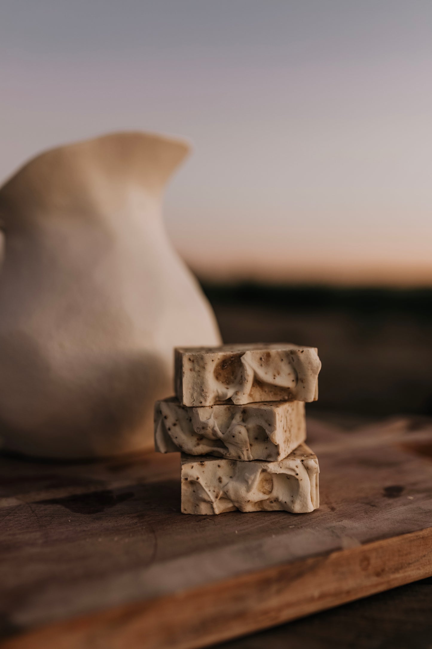 Till & Tallow Bin Bust Soap Degreaser bars stacked on a rustic surface with warm natural light, handcrafted in Alberta.