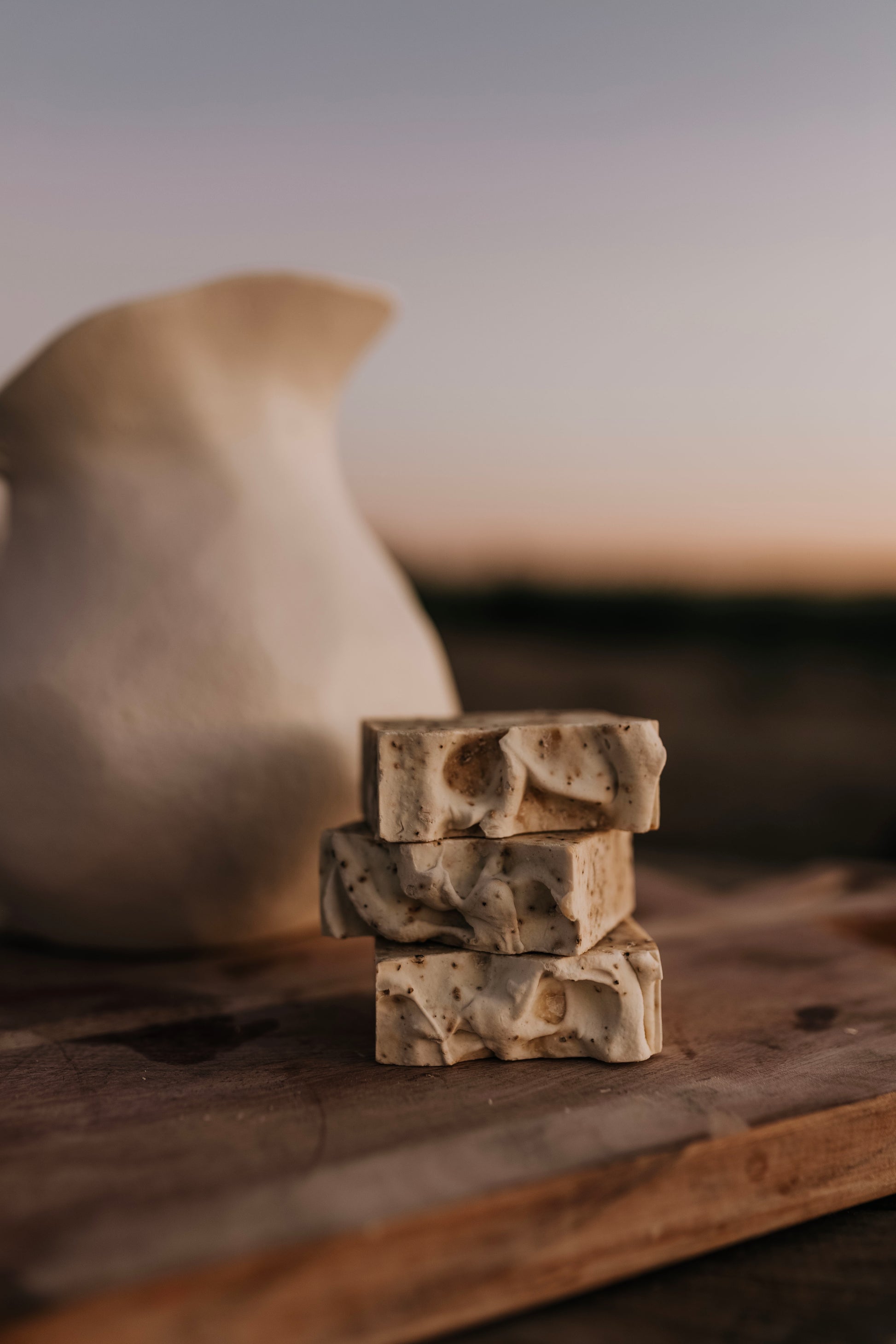 Till & Tallow Bin Bust Soap Degreaser bars stacked on a rustic surface with warm natural light, handcrafted in Alberta.