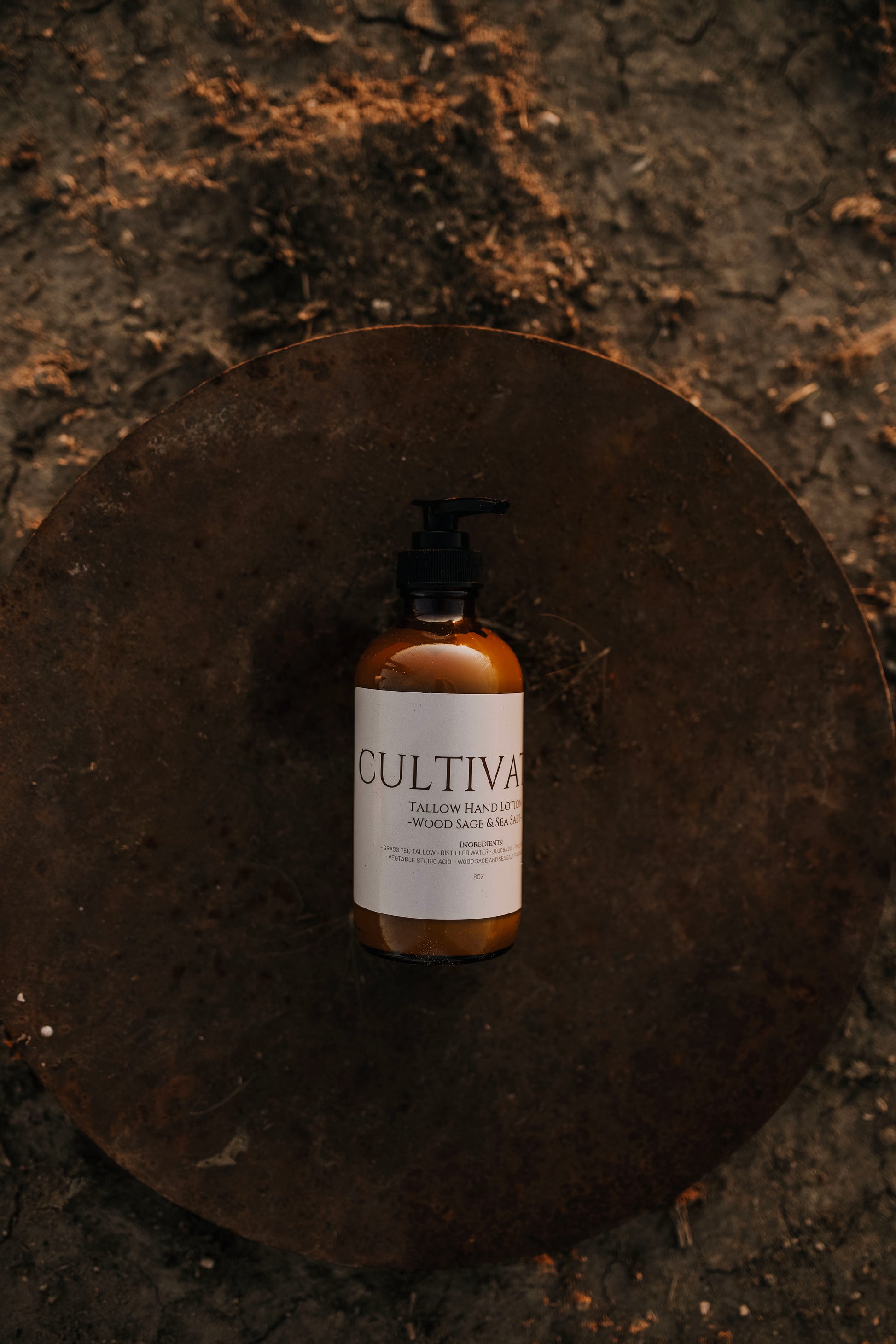 Till & Tallow Cultivated Pump Lotion on Metal disk in the dirt, handcrafted in Alberta.