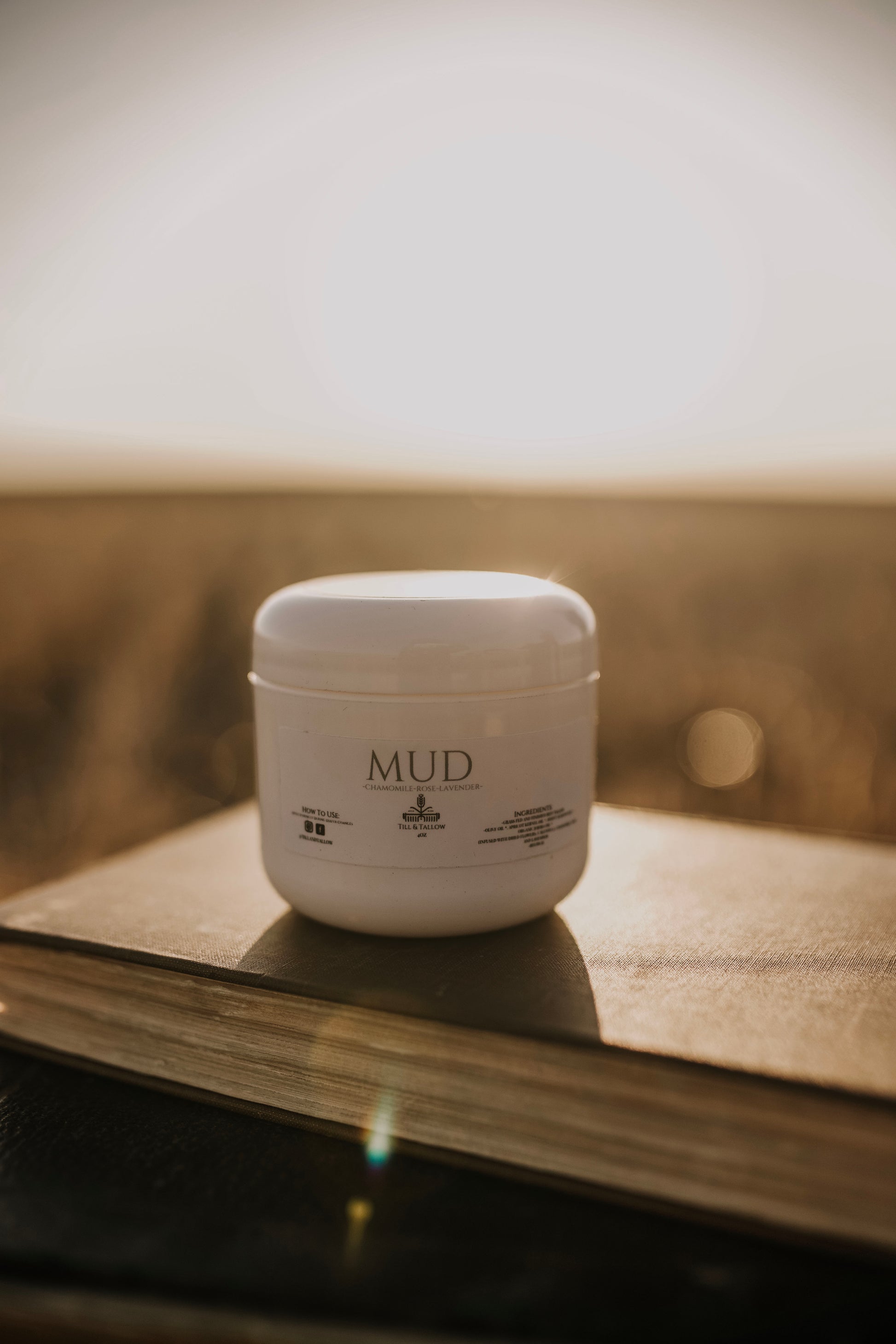 Till & Tallow Mud Bum Balm on book, handcrafted in Alberta.
