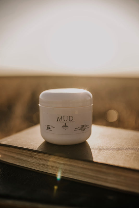 Till & Tallow Mud Bum Balm on book, handcrafted in Alberta.