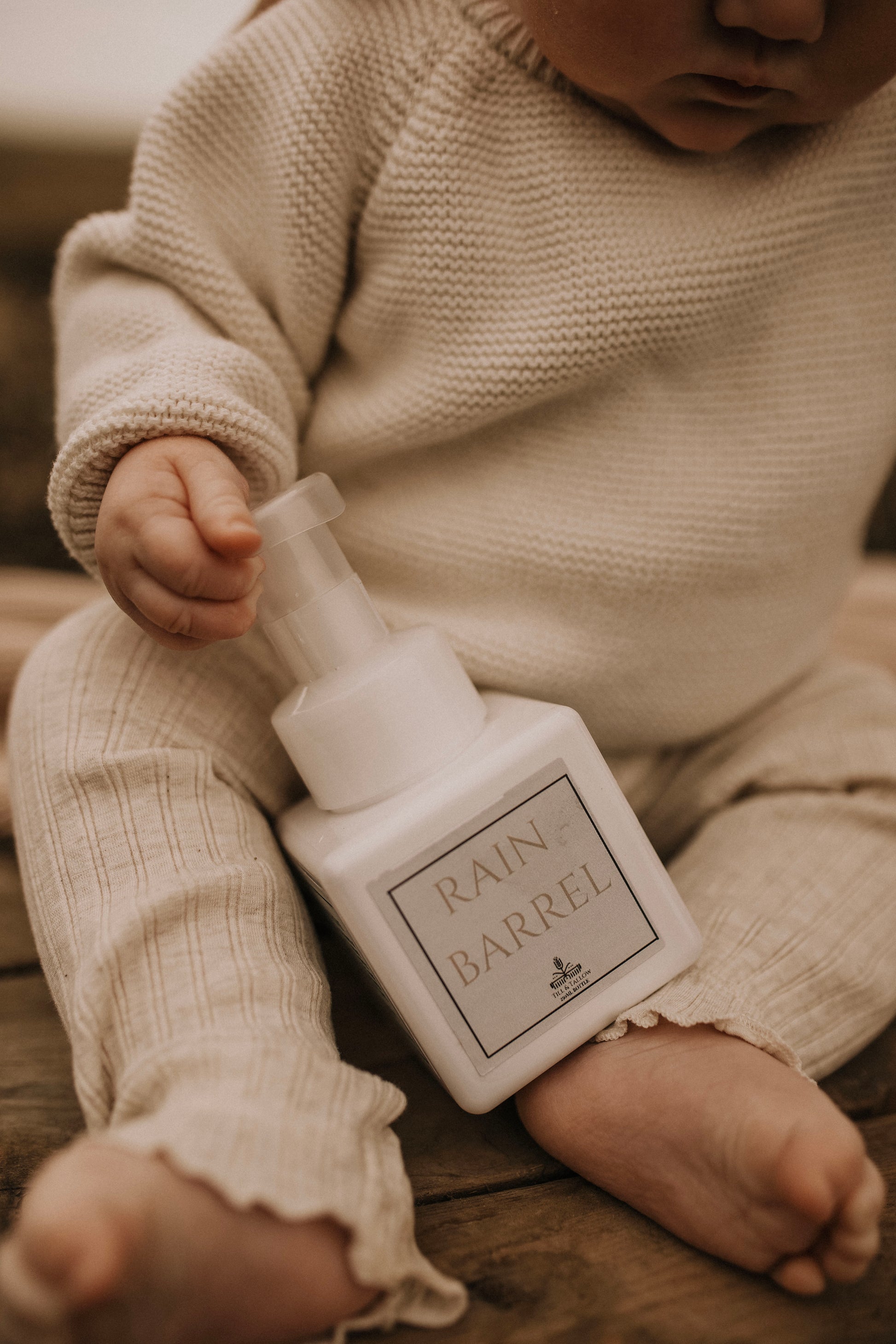 Till & Tallow Rain Barrel Foaming Baby Soap, baby holding, handcrafted in Alberta.