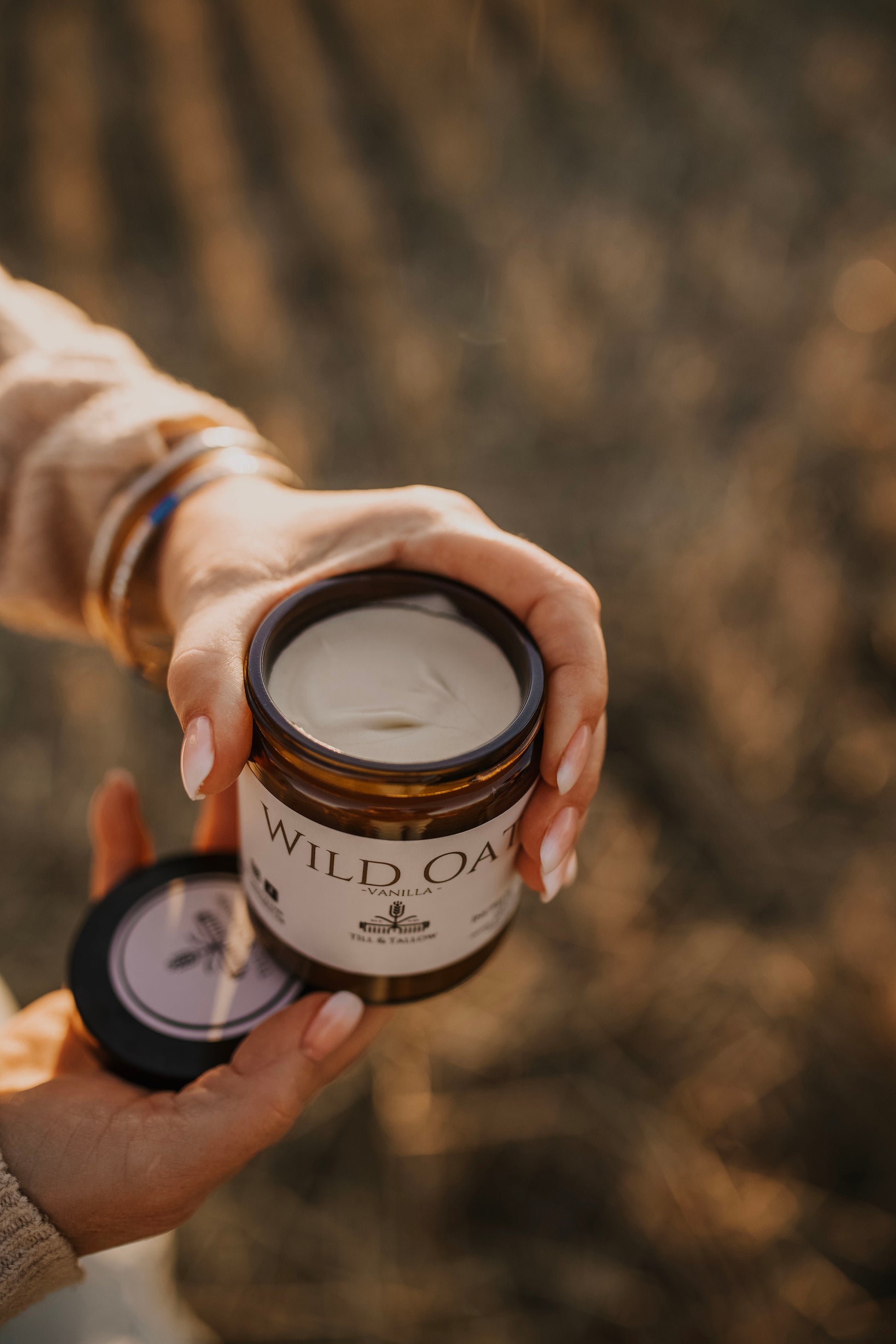 Till & Tallow Wild Oat Vanilla Body Butter holding jar with open lid, handcrafted in Alberta.